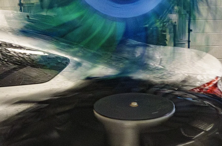 A car passing through an automatic wash with foam and brushes